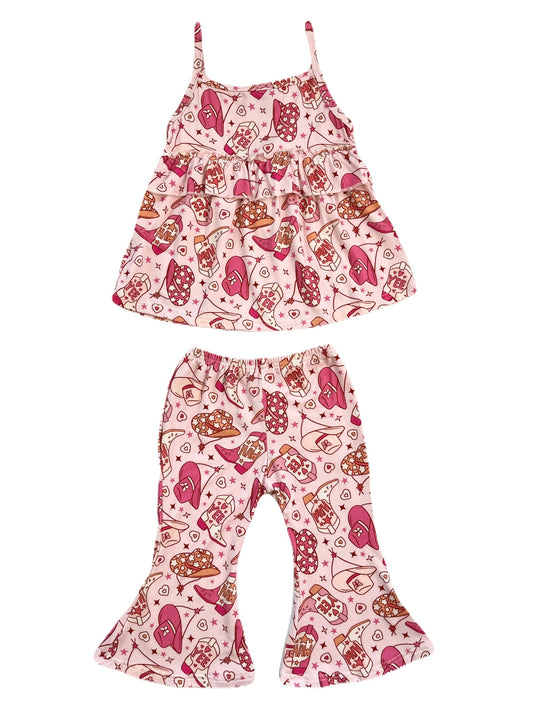 A girl's bamboo spaghetti-strap ruffle tank top and flared pant set with a pink rodeo cowgirl print that features cowboy hats, boots, and the words "yee haw".&nbsp;